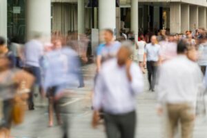 Blurred motion of people walking outside a business district