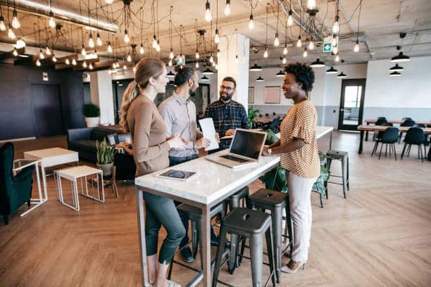 Group of diverse professionals having a discussion around a table in a modern coworking space