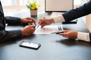 Business professionals signing a contract at a desk