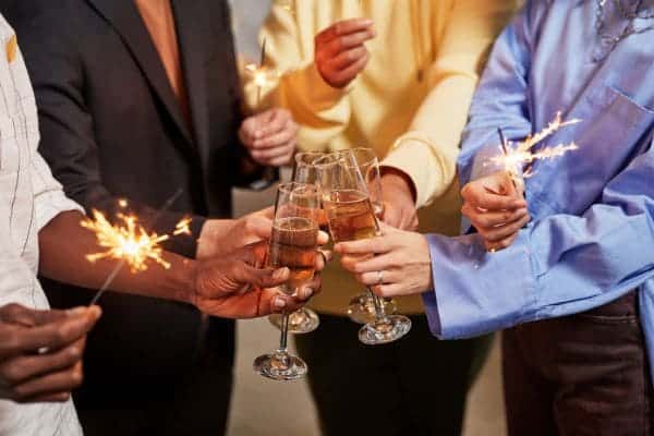 People toasting with champagne and sparklers at a celebration.