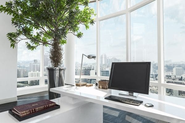 Modern office desk setup with a computer monitor and city skyline view.