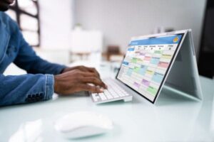 Person typing on keyboard with digital calendar on screen