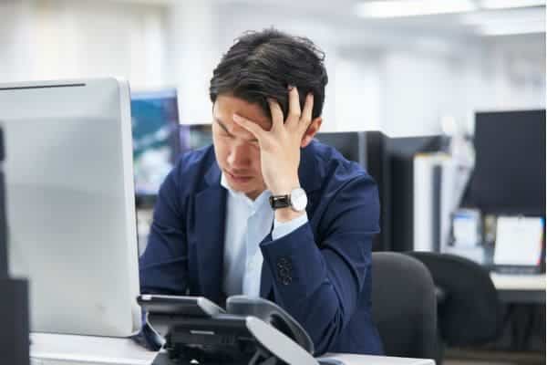 Man stressed while working on computer in office.