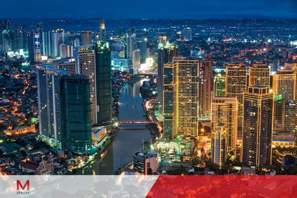 Manila skyline illuminated at night, showcasing vibrant city lights and a festive atmosphere during the holiday season.