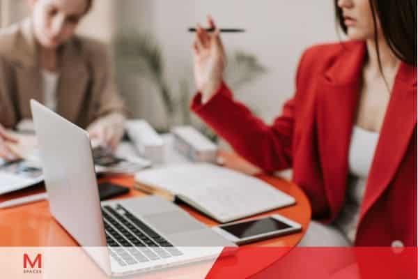 Team meeting with laptop and documents at desk