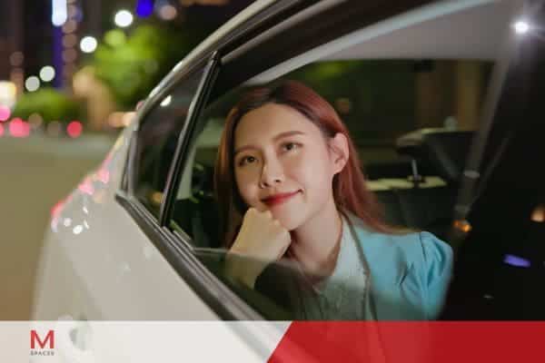 Young woman looking out car window during nighttime city travel