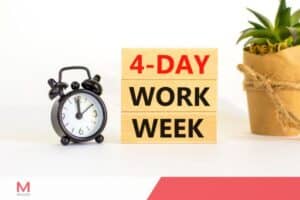 4-day work week concept with wooden blocks, alarm clock, and potted plant on white background