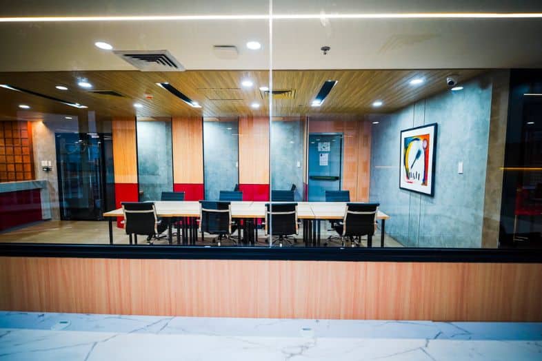 Modern coworking space with glass meeting room and conference tables