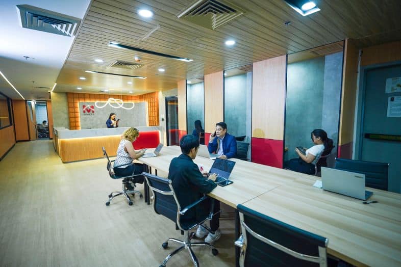 Professionals working in a modern coworking office with shared desks