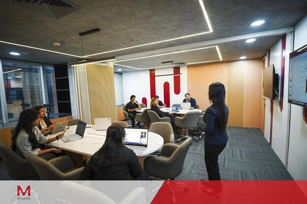 A group of professionals engaged in a meeting around a conference table in a Makati office.